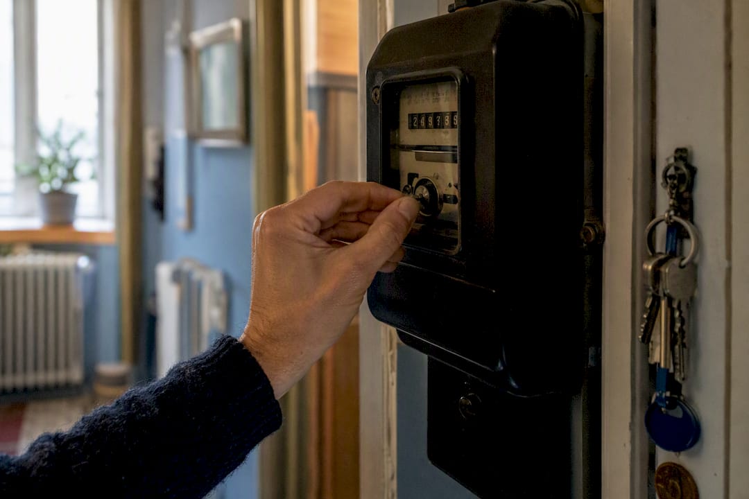 Main lisant un compteur électrique