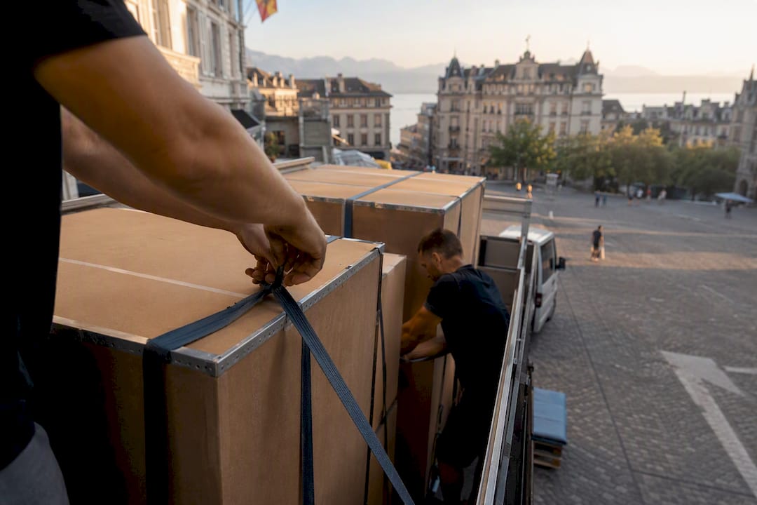 Équipe de déménagement sécurisant une charge de camion à Lausanne