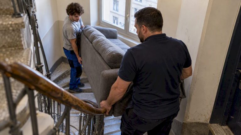 Des déménageurs transportant un canapé dans l'escalier