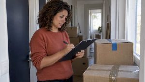 Une personne vérifie une liste de colisage à côté de cartons
